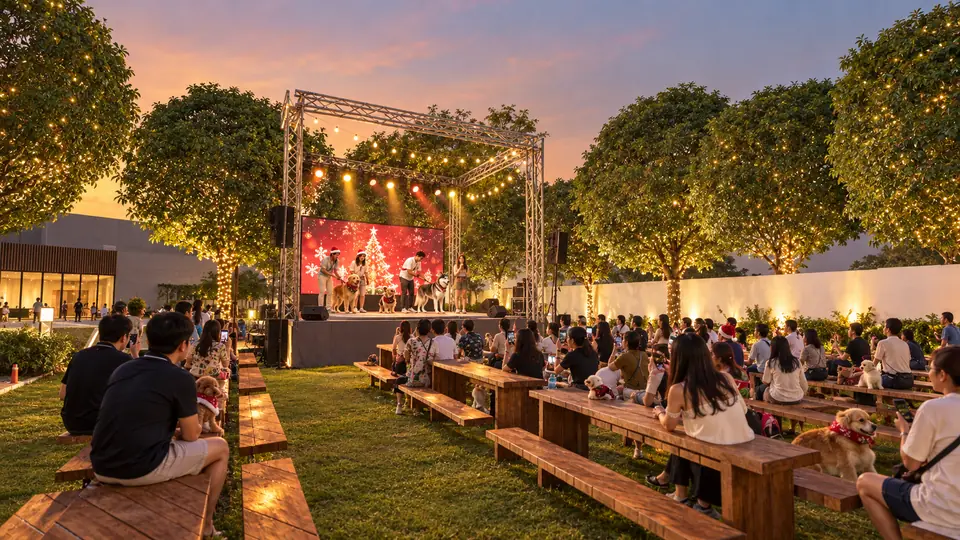 Dogs and owners on the Pet Park stage, watched by an audience on wooden benches on the lawn